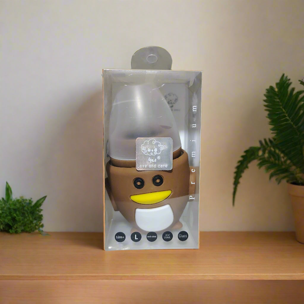 Silicone baby bottle with cartoon face packaging on a white surface