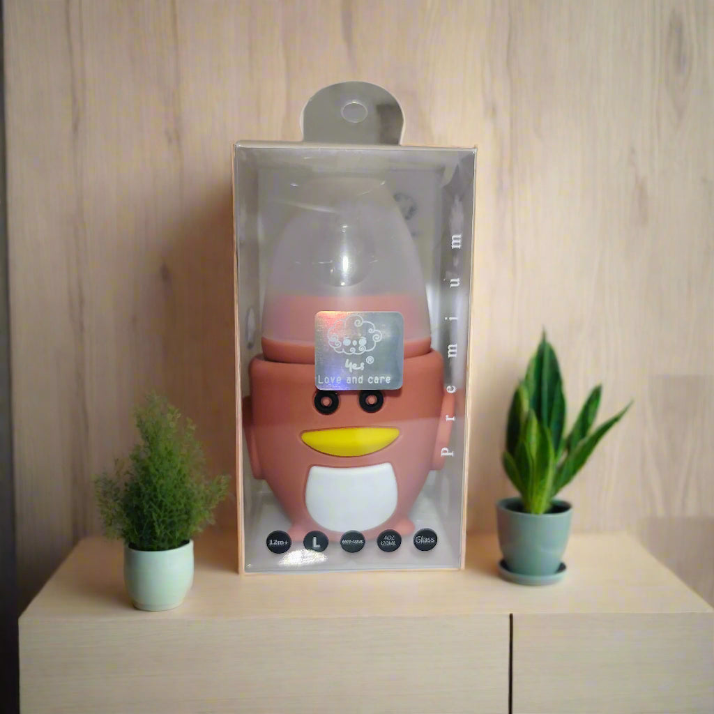 Pink cartoon-like bottle in packaging on a white surface with a blurred background