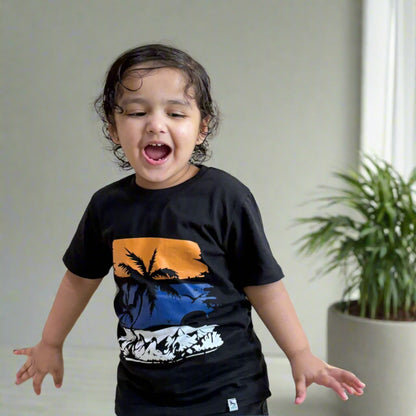 Child wearing a black t-shirt with a colorful design against a plain background