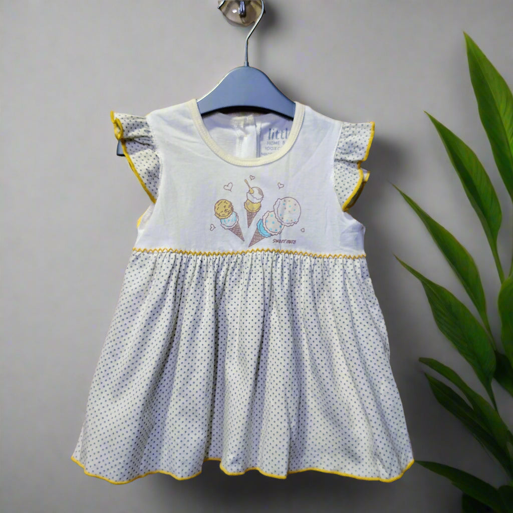 Children's dress with ice cream cone design on a wooden background