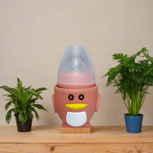 Pink penguin-shaped bottle on a white surface with a blurred indoor background
