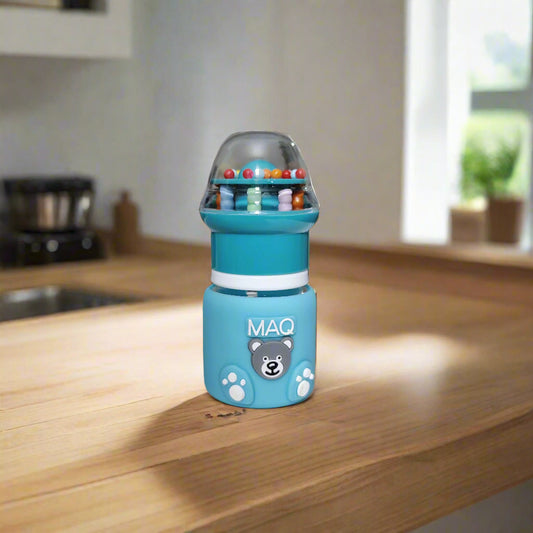 Blue toy bottle with colorful beads on a white surface, blurred indoor background