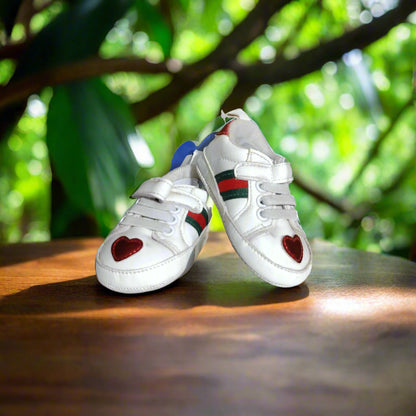White sneakers with heart designs on a white surface
