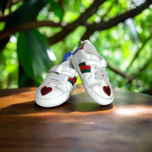 White sneakers with heart designs on a white surface